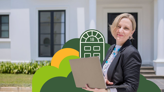 Smiling investor standing outside a house while holding an open laptop