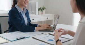 two women sitting at a desk working together